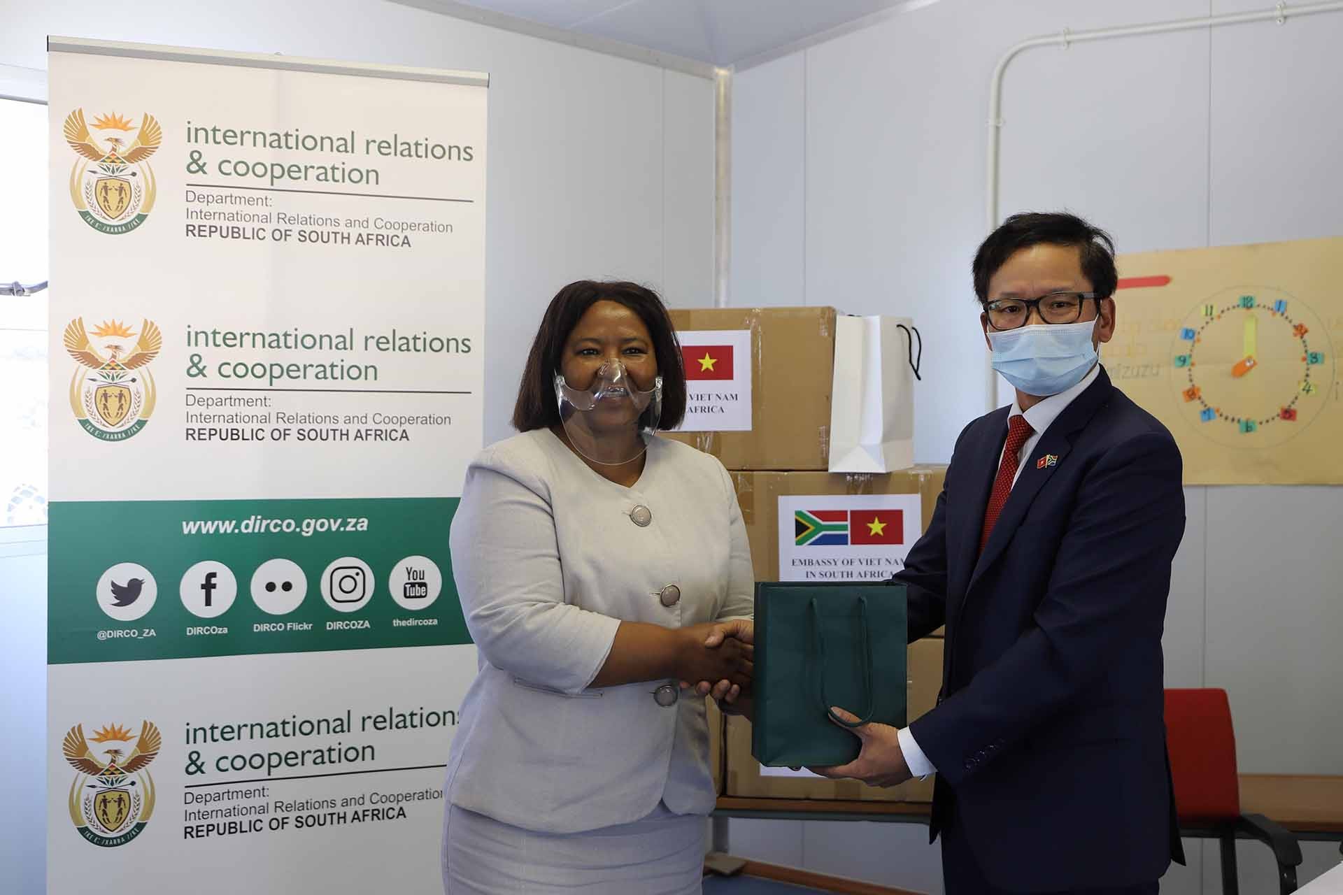 Đại sứ Hoàng Văn Lợi trao tặng khẩu trang cho Cô Yvonne Dingiswayo, Hiệu trưởng Trường Tiểu học Tabatha. (Nguồn: TTXVN)