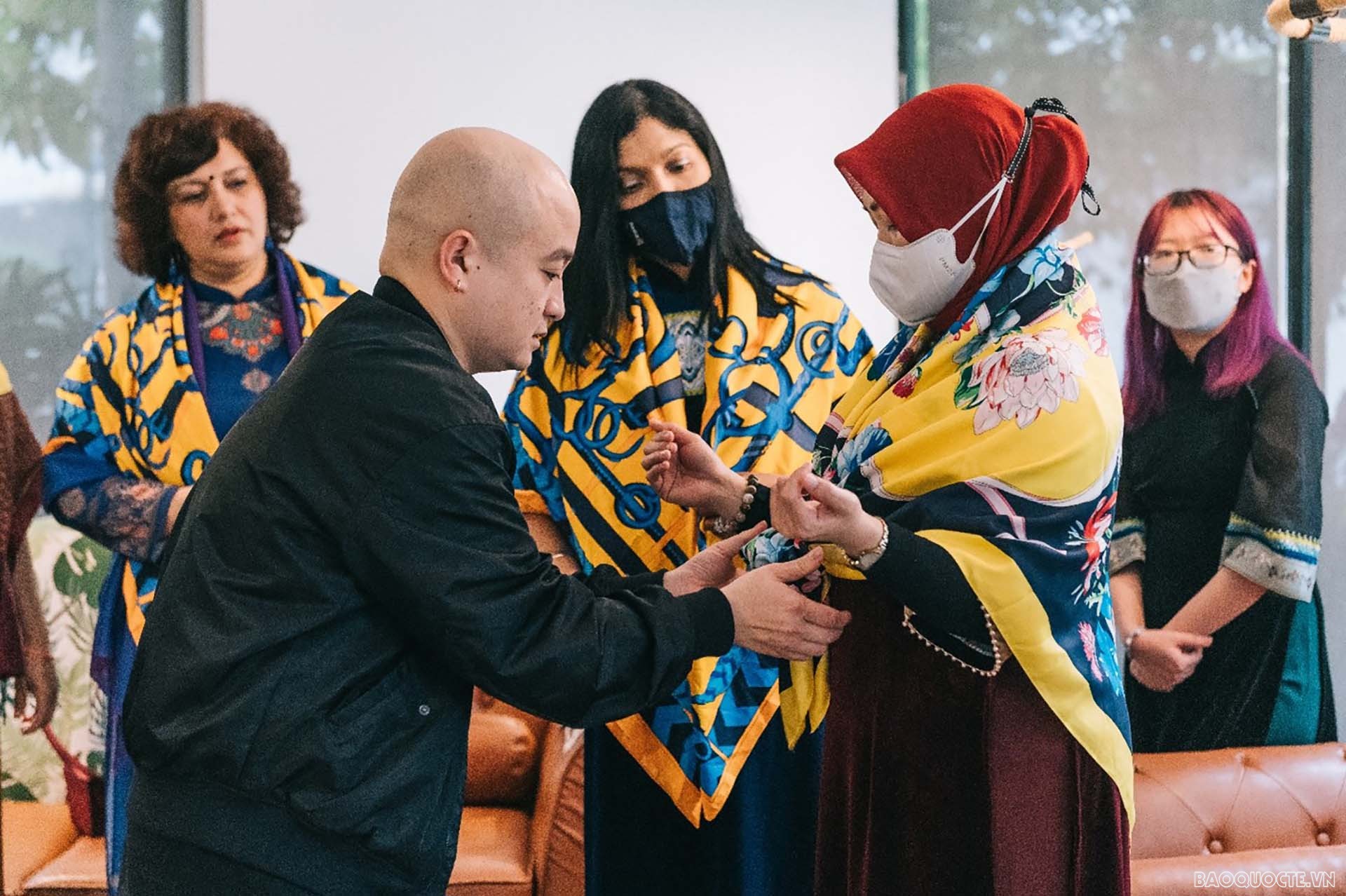 Các khách mời thực hành thắt khăn lụa.