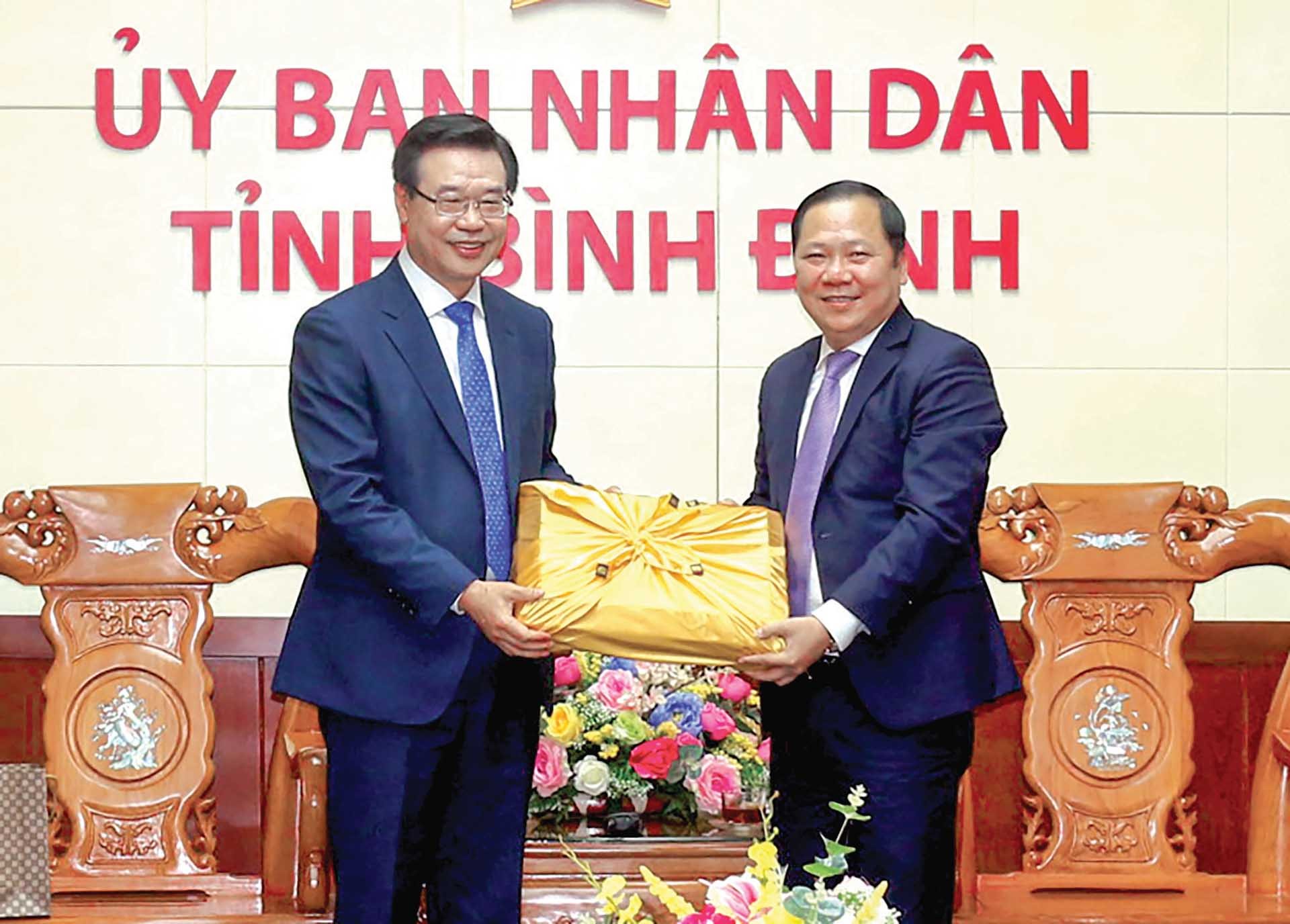 Quận trưởng Quận Yongsan Sung Jang Hyun (bên trái) tặng quà lưu niệm cho Chủ tịch UBND tỉnh Bình Định Nguyễn Phi Long.