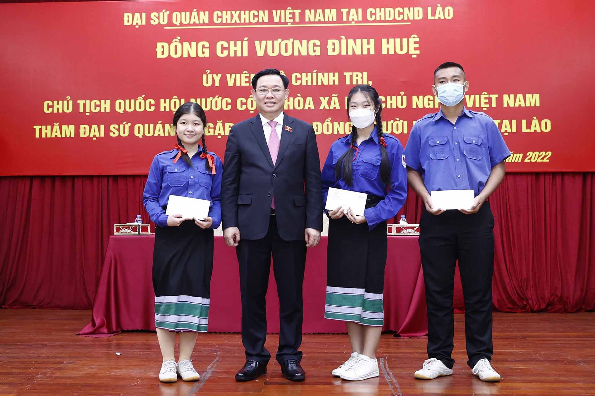 Chủ tịch Quốc hội Vương Đình Huệ tặng quà học sinh trong cộng đồng người Việt Nam tại Lào. (Nguồn: TTXVN)