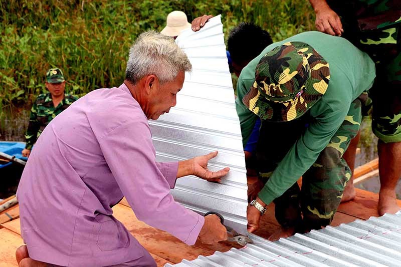 Ông Đỗ Văn Nhẫn, Hội viên Nông dân xã Nhơn Hưng, Tịnh Biên là thợ chính giúp cán bộ, chiến sĩ Đồn BP Nhơn Hưng xây dựng chốt vượt lũ kiểu mẫu. (Ảnh: Chiến Khu)