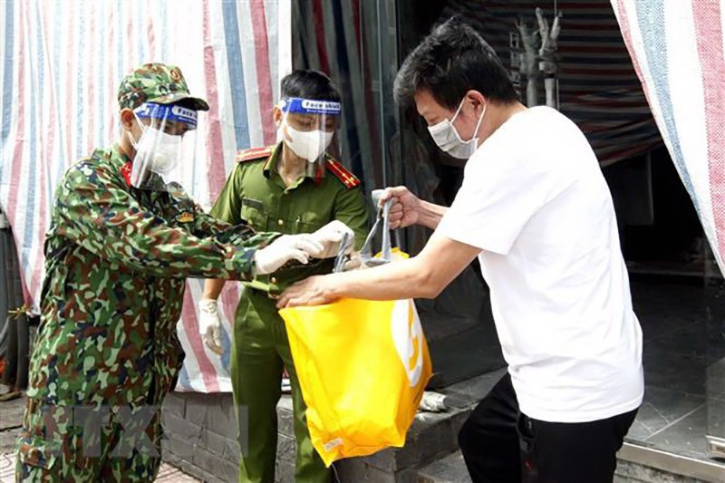 Cán bộ chiến sỹ Trung đoàn 1, Sư đoàn 9, Quân đoàn 4 cùng cảnh sát khu vực phường Võ Thị Sáu, Quận 3 trao túi hỗ trợ cho những người ở trọ có hoàn cảnh khó trong những ngày thành phố giãn cách xã hội. (Nguồn: TTXVN)