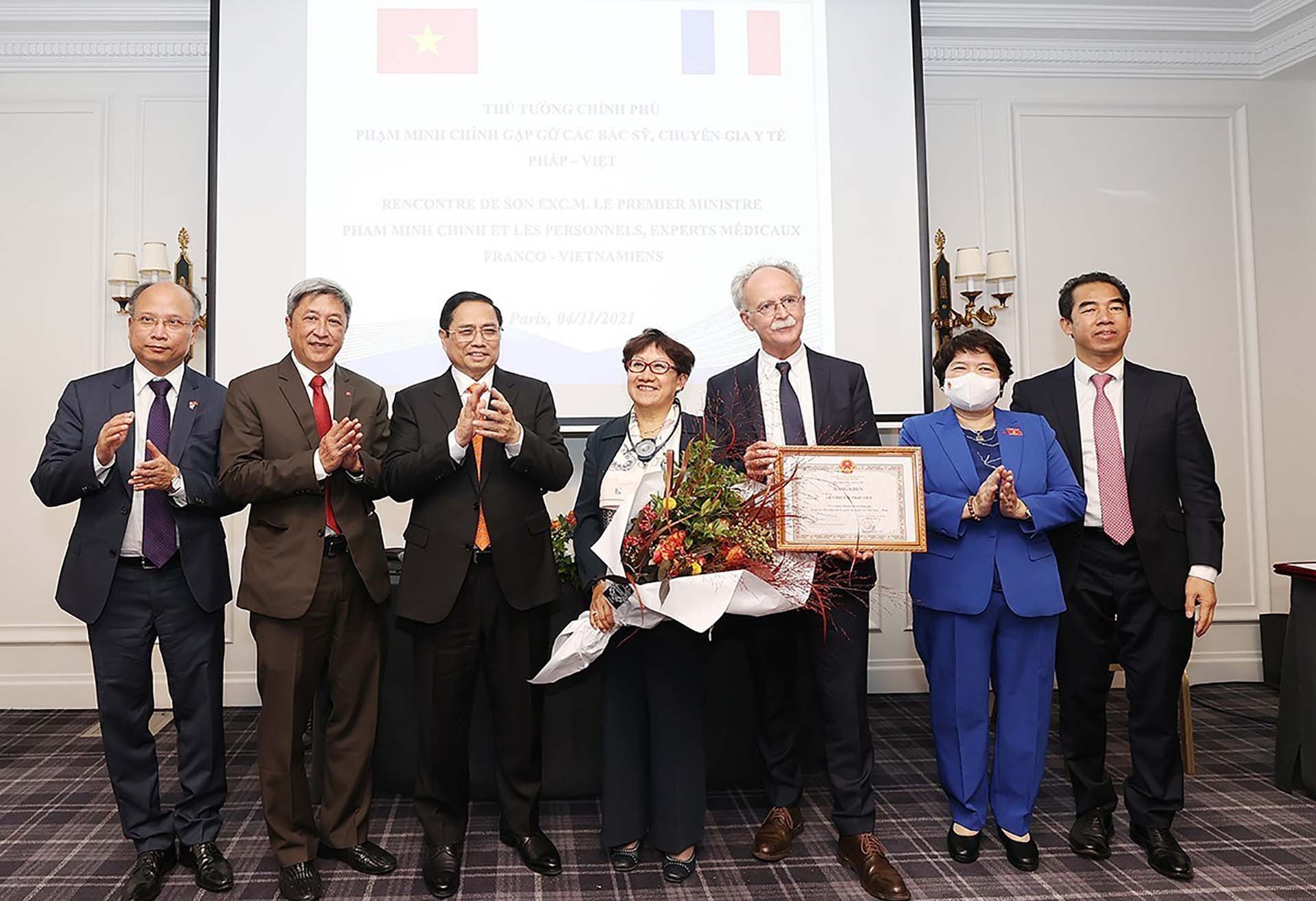 Thủ tướng Phạm Minh Chính với đại diện Liên hội Y tế Pháp-Việt được nhận bằng khen của Bộ Y tế. (Nguồn: TTXVN)