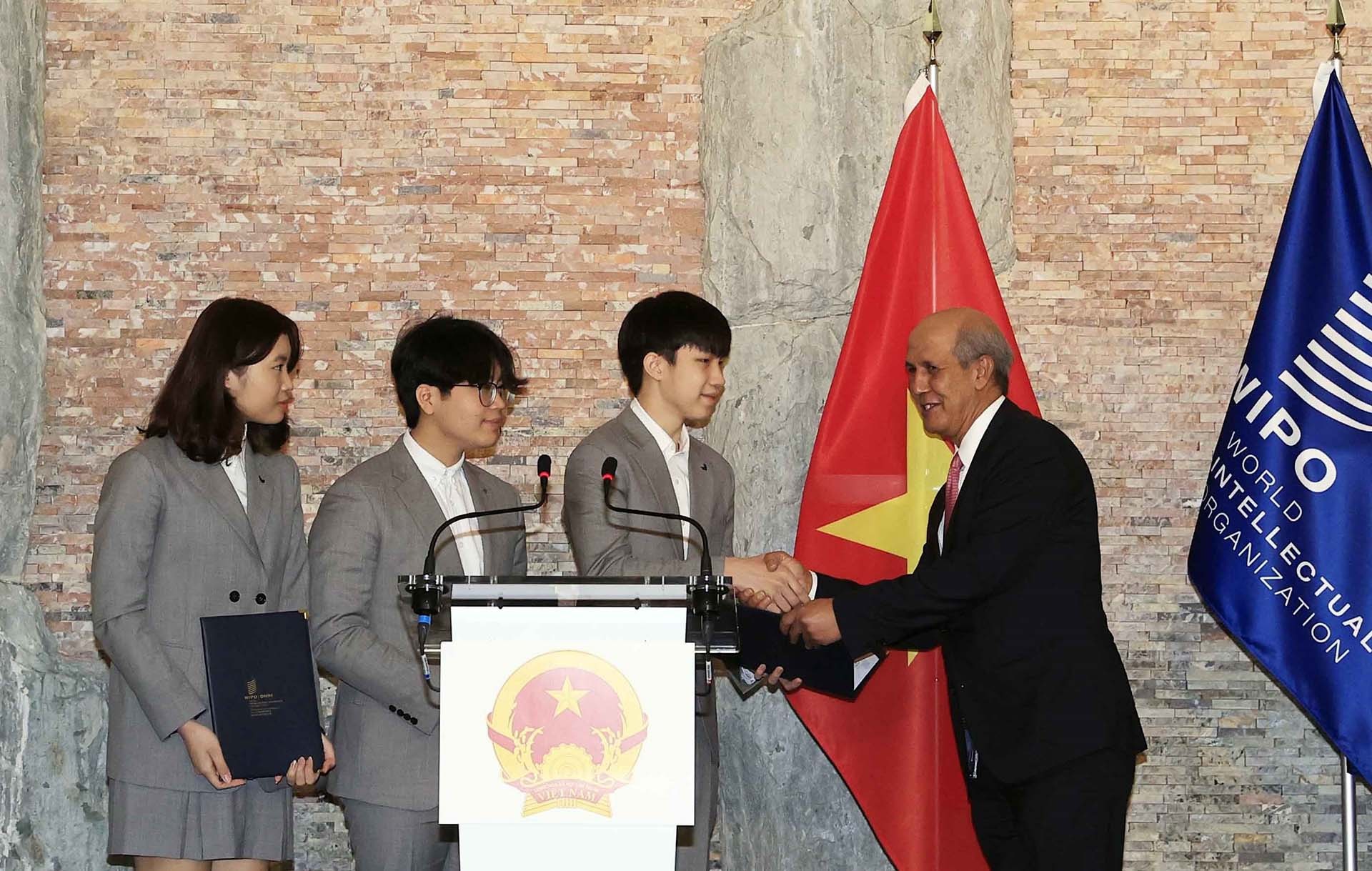 Đại diện Tổ chức sở hữu Trí tuệ Thế giới (WIPO) trao danh hiệu Đại sứ trẻ sở hữu trí tuệ của WIPO cho nhóm các nhà sáng chế trẻ mũ Vihelm (mũ chống Covid 19). (Nguồn: TTXVN)