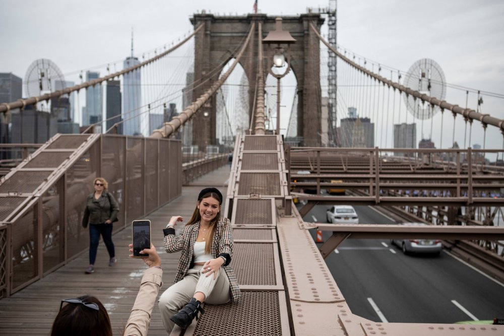 A visitor from Mexico took photos on the Brooklyn Bridge. The number of tourists to New York City plunged to 22 million last year from 66 million in 2019.Credit...Kirsten Luce for The New York Times A visitor from Mexico took photos on the Brooklyn Bridge. The number of tourists to New York City plunged to 22 million last year from 66 million in 2019.Credit...Kirsten Luce for The New York Times