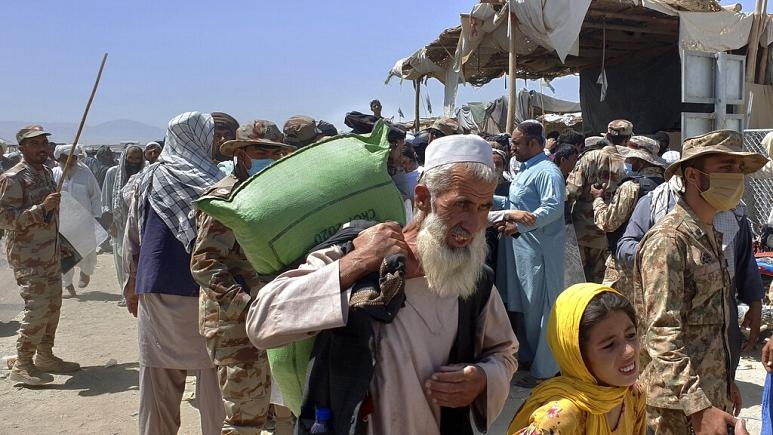 Cảnh sat Pakistan quan sát dòng người đang hướng tới biên giới với Afghanistan tại tỉnh Chaman, Pakistan, ngày 13/4. (Nguồn: AP) 