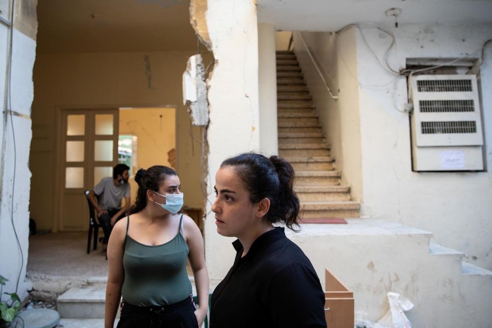 Người dân tại sân của khu nhà họ đang sống bị phá hủy sau vụ nổ. Ảnh: Reuters. 5059-tyi-xuyng