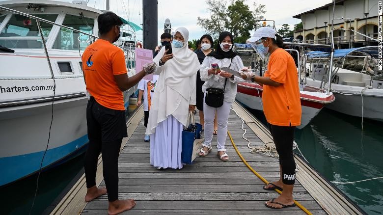 Hành khách quét một ứng dụng để theo dõi tình trạng sức khỏe trước khi lên du thuyền ở Langkawi, Malaysia, ngày 17/9.