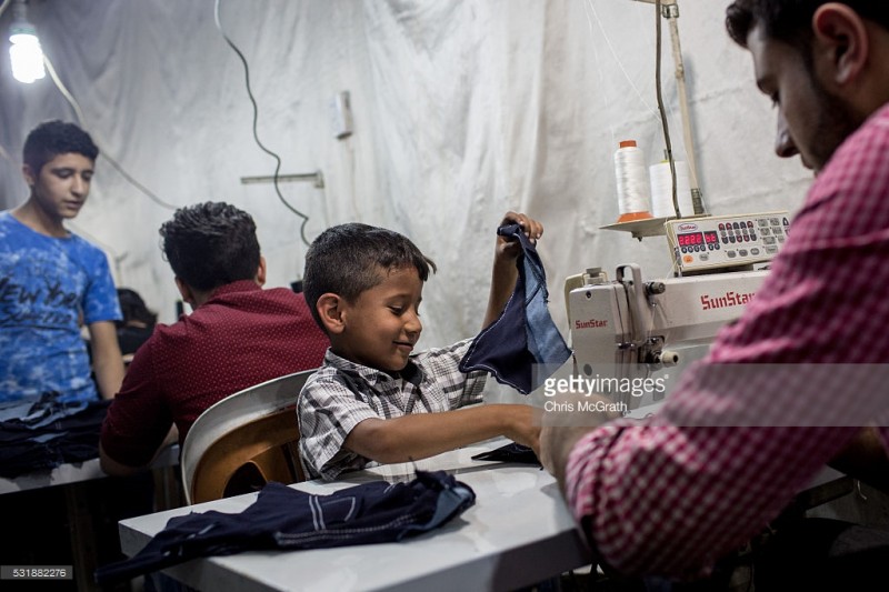 tre em syria trong mot xuong may tren dat tho