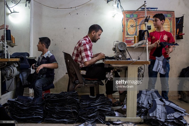 tre em syria trong mot xuong may tren dat tho