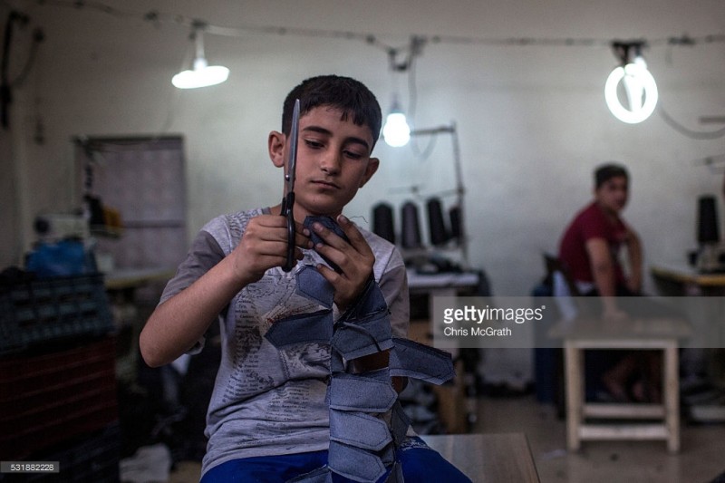 tre em syria trong mot xuong may tren dat tho