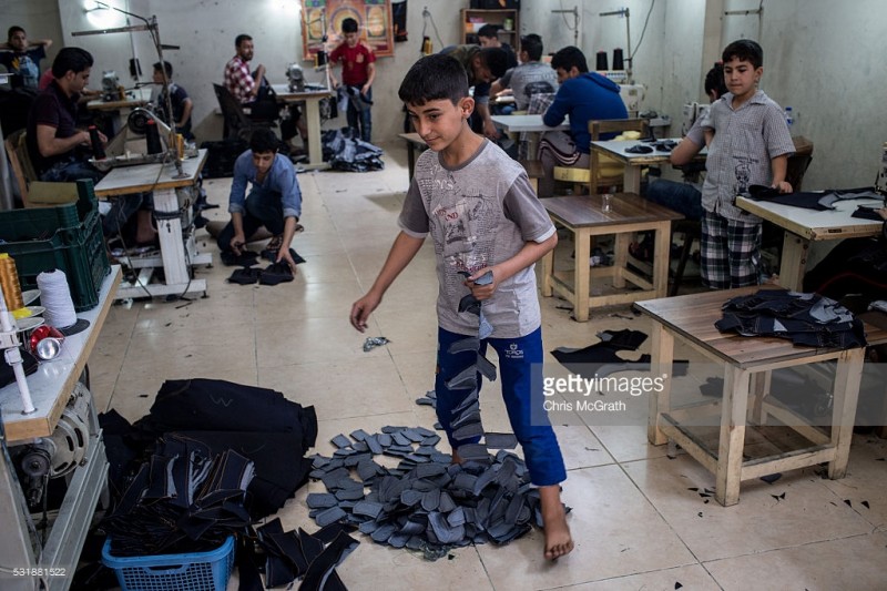 tre em syria trong mot xuong may tren dat tho