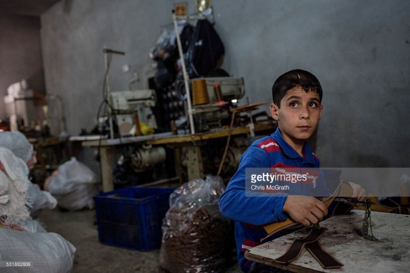 tre em syria trong mot xuong may tren dat tho