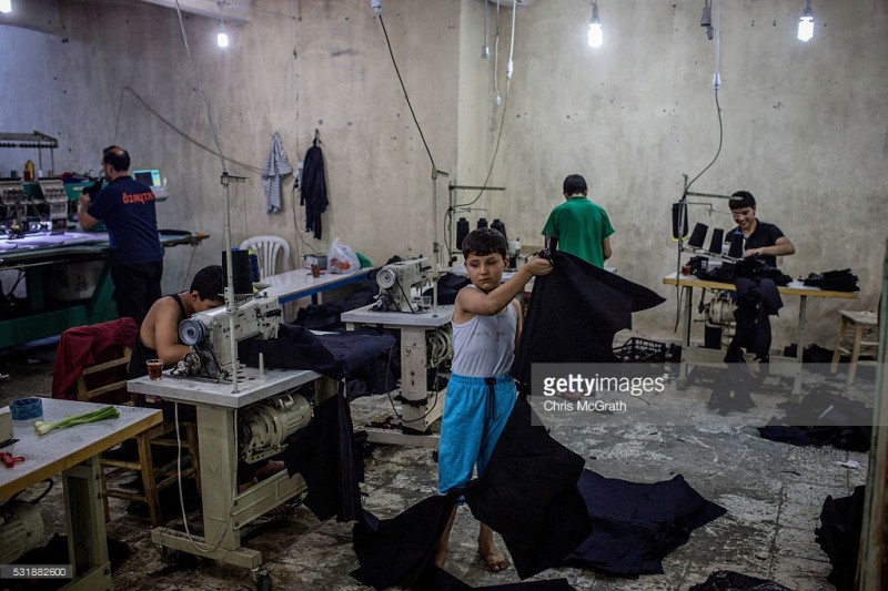 tre em syria trong mot xuong may tren dat tho