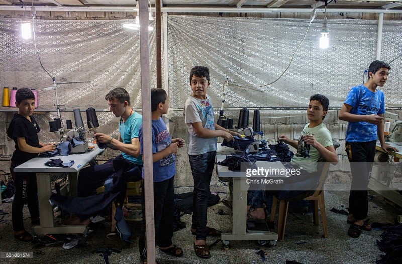 tre em syria trong mot xuong may tren dat tho