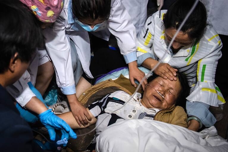 Trong bức ảnh do Tân Hoa xã của Trung Quốc công bố, các nhân viên y tế điều trị cho một phụ nữ sau trận động đất ở huyện tự trị Yangbi Yi ở tỉnh Vân Nam, miền tây nam Trung Quốc, vào đầu thứ Bảy, ngày 22 tháng 5 năm 2021. Một trận động đất mạnh đã xảy ra hai tỉnh ở Trung Quốc . (Nguồn Washi poect