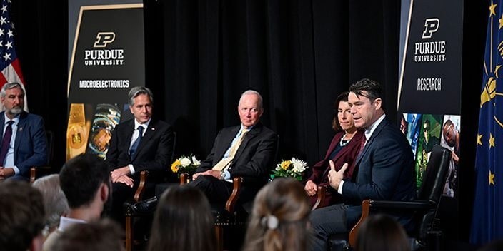 Từ trái qua, Thống đốc bang Indiana Eric J. Holcomb, Ngoại trưởng Hoa Kỳ Antony Blinken, Chủ tịch Purdue Mitch Daniels, Bộ trưởng Thương mại Hoa Kỳ Gina Raimondo và Thượng nghị sĩ Hoa Kỳ Todd Young tham gia vào một cuộc trò chuyện bên lửa sau chuyến tham quan các cơ sở vi điện tử của Purdue (Đại học Purdue ( Nguồn: purdue)