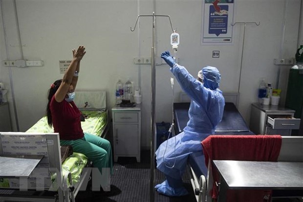 Nhân viên y tế hỗ trợ bệnh nhân COVID-19 tập luyện sau khi hồi phục tại bệnh viện ở Sullana, Piura, miền Bắc Peru. 