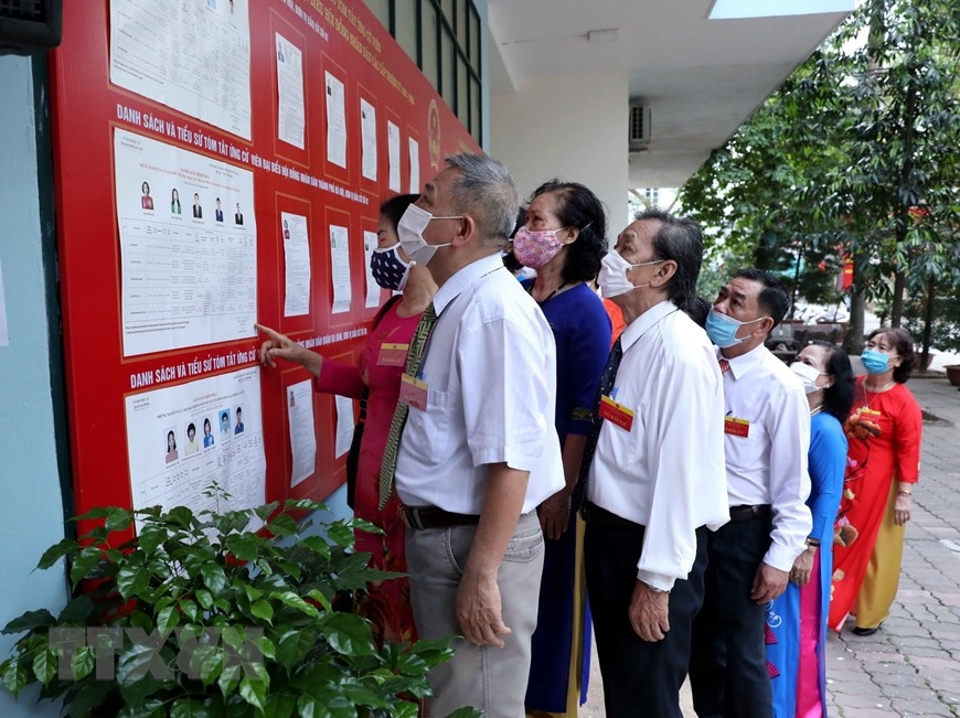 Người dân xem danh sách cử tri tại khu vực bỏ phiếu số 4, phường Vĩnh Phúc, Quận Ba Đình, Hà Nội. (Ảnh: Phạm Kiên/TTXVN)