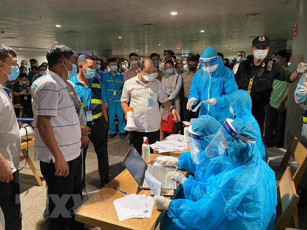 Nhân viên y tế làm thủ tục lấy mẫu xét nghiệm cho người làm việc tại sân bay Tân Sơn Nhất, ngày 6/2. (Nguồn: TTXVN)