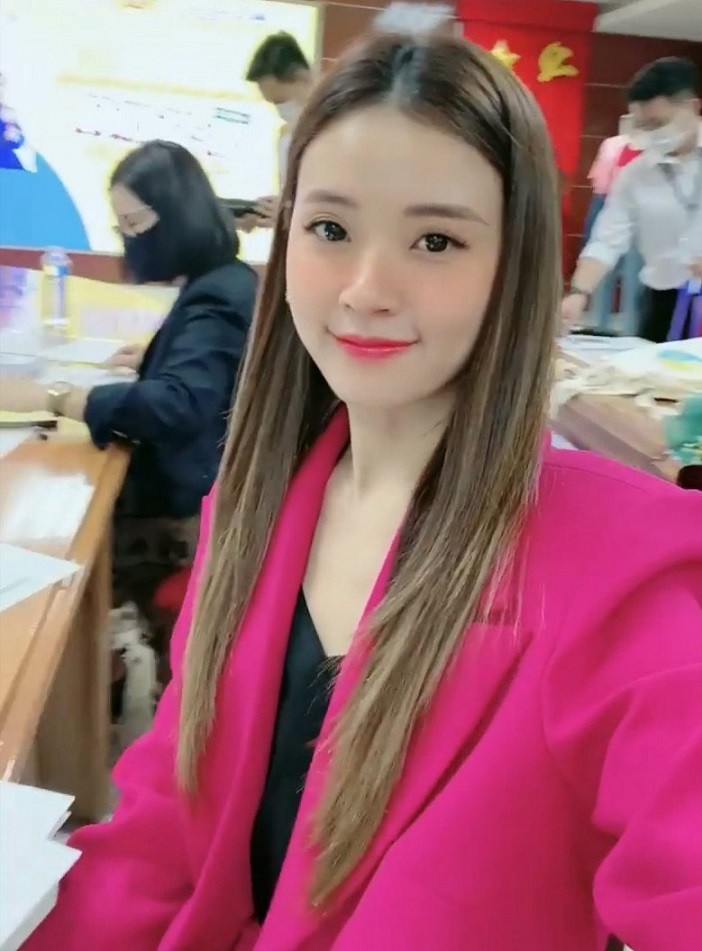 Nữ giảng viên chọn bộ suit hồng neon tôn da trắng, phối cùng áo lụa đen phía trong.