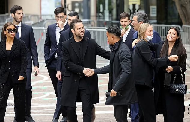 Cựu tiền vệ Chelsea Cesc Fabregas bắt tay với Justin Kluivert - con trai huyền thoại Hà Lan Patrick Kluivert - bên ngoài nhà thờ. Fabregas đi cùng bà xã Daniella Semaan (ngoài cùng bên trái) tới đám tang. Justin Kluivert là một trong những khách hàng của Mino Raiola. Fabregas không cộng tác với 'siêu cò' nhưng anh đang thi đấu ở Monaco nên tới tiễn đưa Mino Raiola.