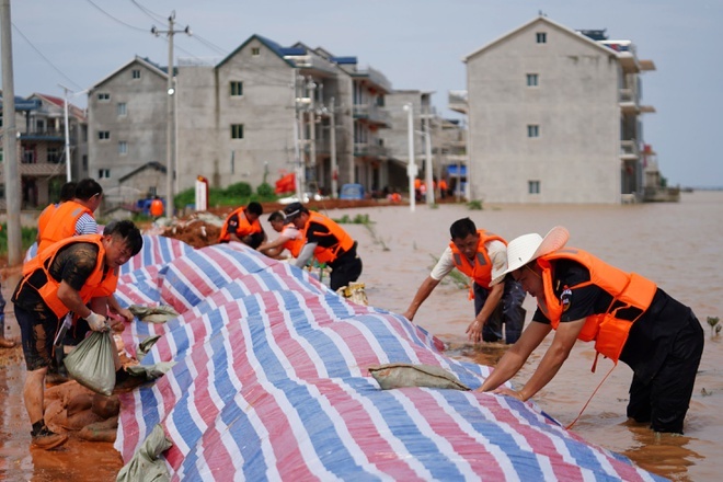 Cán bộ địa phương tại huyện Bà Dương, tỉnh Giang Tây, Trung Quốc khẩn trương củng cố đê bao ứng phó lũ lụt ngày 11/7. (Nguồn: Tân Hoa xã 5206 trung quoc lu lut 1