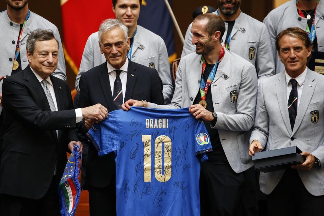 Toàn đội Italia trong buổi lễ mừng công với Thủ tướng Mario Draghi. Họ đã dành tặng cho ông chiếc áo số 10 với chữ ký của các cầu thủ. (Nguồn: 