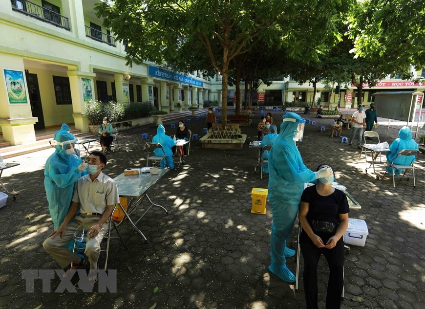 Nhân viên y tế lấy mẫu xét nghiệm Covid-19 cho người dân phường Nghĩa Đô, quận Cầu Giấy. (Nguồn: TTXVN)