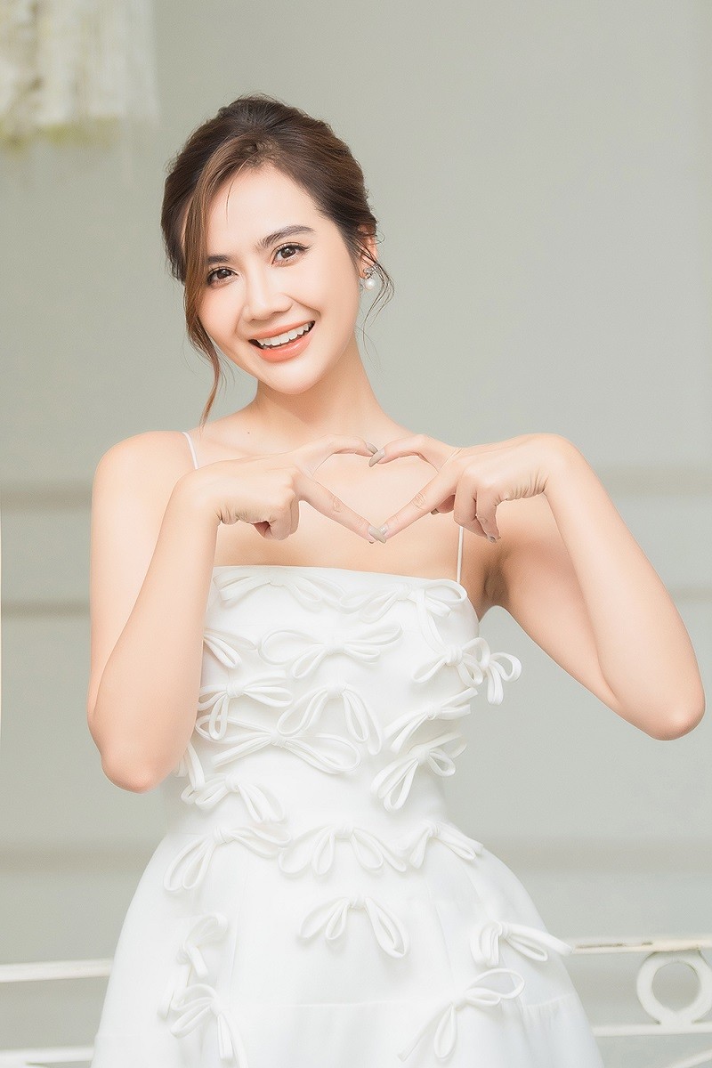 Cô đan tay hình trái tim để bày tỏ tình cảm với mọi người.