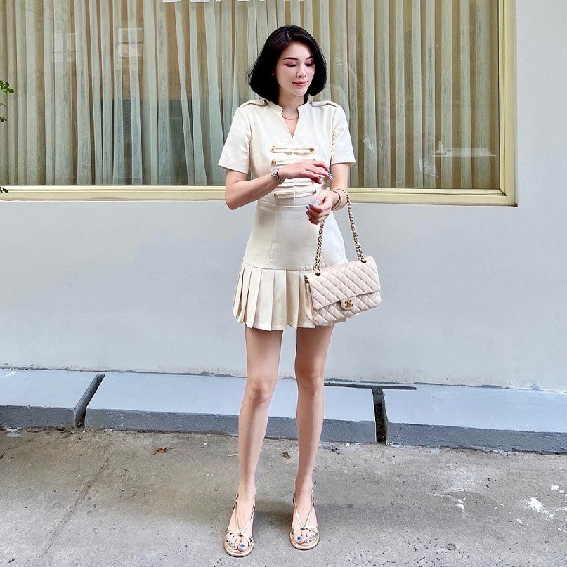 Linh Rin diện đồ phong cách tiểu thư tông nude nhẹ nhàng. Trang phục ăn ý từ bộ đầm local brand đến sandals quai mảnh và chiếc túi Chanel hợp mốt.