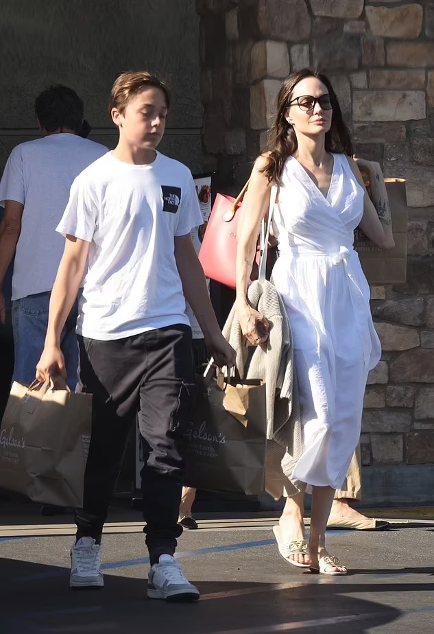 Knox cùng Angelina mua đồ ở cửa hàng tạp hóa tại Los Angeles hôm 15/8. Cậu phụ mẹ xách hai túi nặng ra xe.