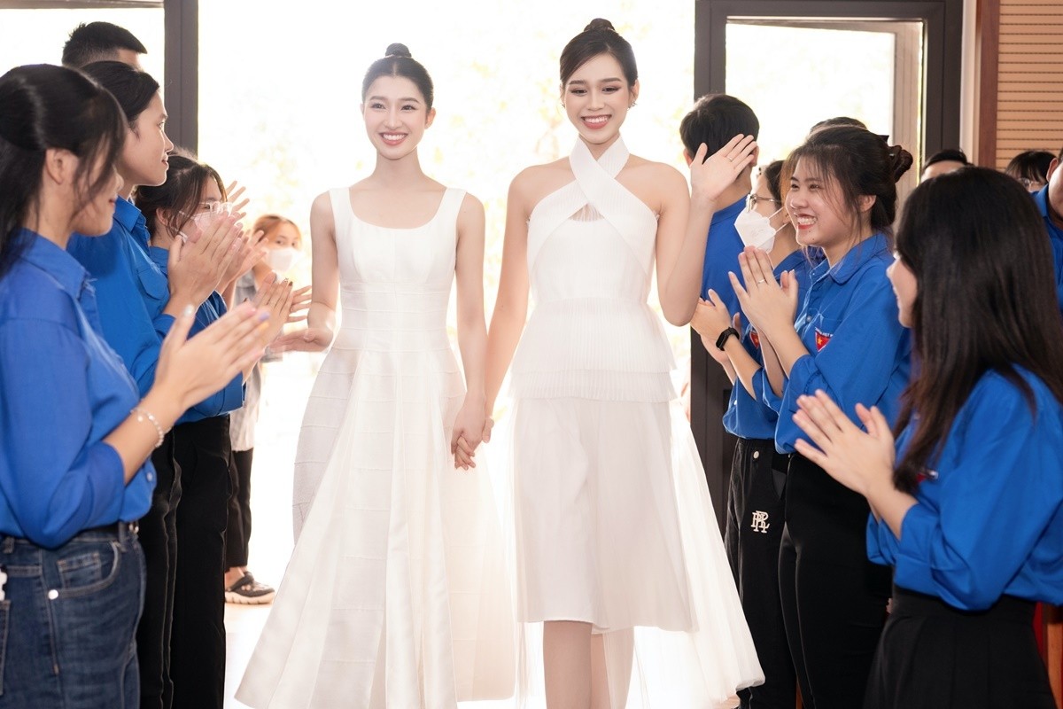 Hai người đẹp quê Thanh Hóa được sinh viên địa phương vây quanh chào đón. Thiếu ngủ do bận rộn với lịch trình dày đặc nhưng họ vẫn rạng rỡ trước ống kính.