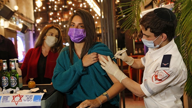 Một nhân viên y tế tiêm vaccine ngừa Covid-19 cho một người Israel tại một quán bar ở Tel Aviv vào ngày 18/2. (Nguồn: AFP/Getty Images)