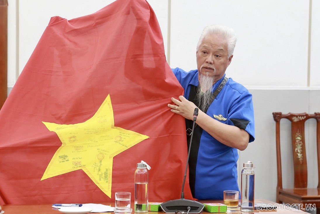 Ông Nguyễn Trọng Đức, kiều bào Mỹ xúc động khi nói về lá cờ Việt Nam có có chữ ký của các cán bộ, chiến sỹ, người dân trên quần đảo Trường Sa. (Ảnh: Duy Quang)
