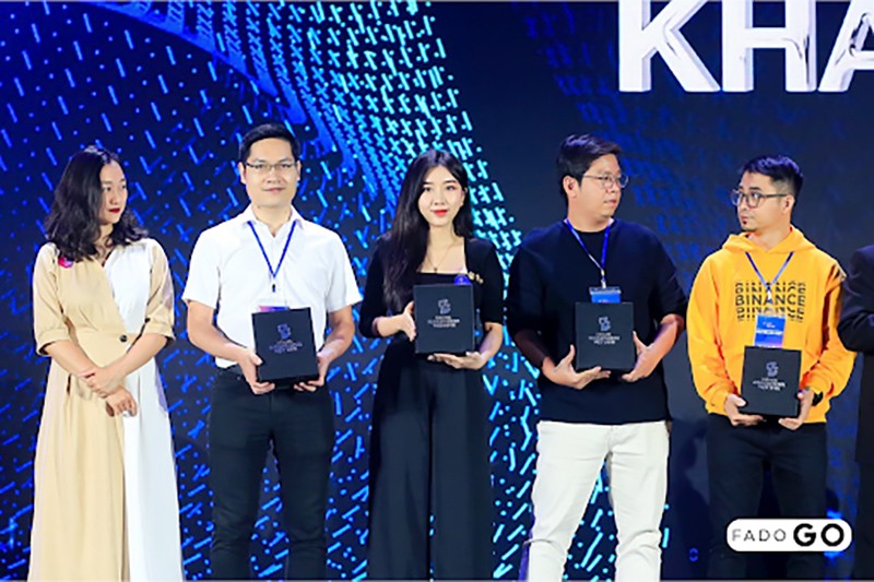 Phó Tổng Giám đốc Phạm Thị Ngọc Anh (mặc áo đen ở giữa) đại diện Fado Group nhận quà từ Hiệp hội Blockchain Việt Nam.