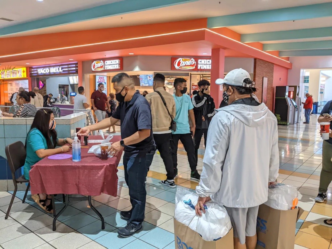 Thực khách xuất trình hồ sơ tiêm chủng và số điện thoại đã đăng ký trước khi bước vào khu ẩm thực Micronesia Mall vào ngày 30 tháng 8, ngày Guam khôi phục quy định bắt buộc đeo mặt nạ và các quy tắc tránh xa xã hội đối với các địa điểm trong nhà. (Lyric Li / The Washington Post)