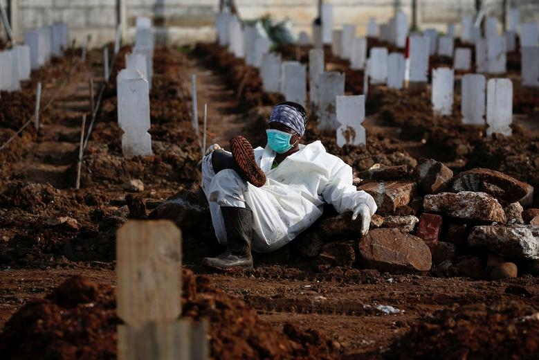 Công nhân dịch vụ tang lễ tranh thủ nghỉ ngơi tại một nghĩa trang do chính phủ chỉ định dành cho các nạn nhân của dịch Covid-19 ở Jakarta, Indonesia. (Nguồn: Reuters)