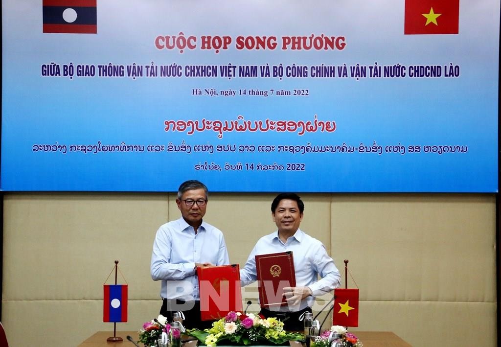 Bộ trưởng Bộ Giao thông Vận tải Nguyễn Văn thể và Bộ trưởng Bộ Công chính và Vận tải Lào Viengsavath Siphandone ký Biên bản cuộc họp. Ảnh: Quang Toàn/BNEWS/TTXVN