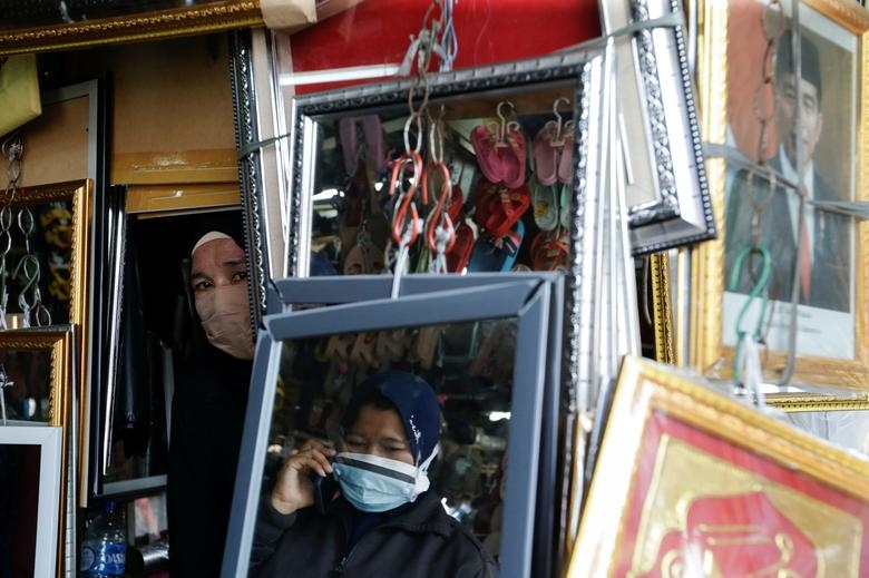 Người phụ nữ đeo khẩu trang khi bán hàng trong bối cảnh dịch Covid-19 đang bùng phát dữ dội ở Jakarta, Indonesia, ngày 18/8. (Nguồn: Reuters)