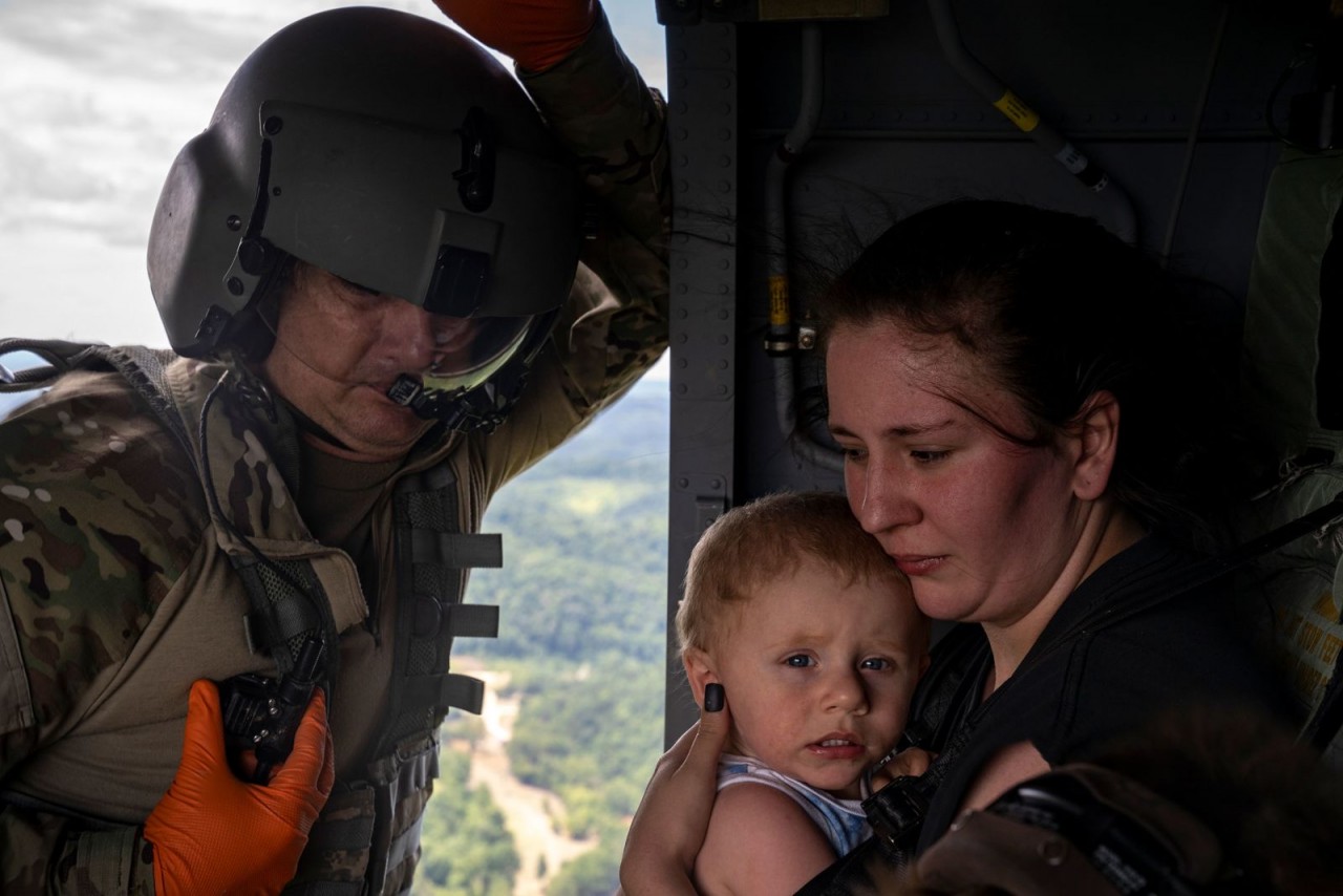 Sĩ quan Tim Lewis của Lực lượng vệ binh quốc gia Kentucky đưa Candace Spencer và con trai cô, Wyatt lên trực thăng, ra khỏi vùng ngập lụt South Fork, Kentucky, Mỹ, ngày 30/7. Mưa lớn dẫn đến lũ lụt trên diện rộng ở miền Đông Kentucky khiến ít nhất 37 ngườ