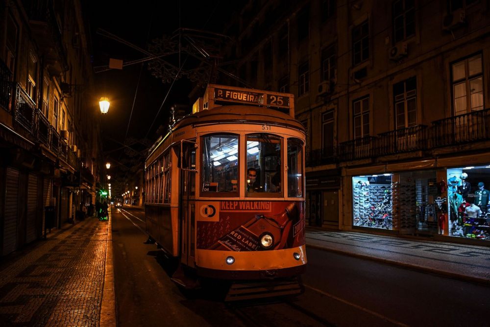 Chiếc xe điện vắng khách chạy qua một con đường vắng ở trung tâm thành phố Lisbon, Bồ Đào Nha, ngày 9/11. Quốc gia châu Âu đã ban hành lệnh giới nghiêm trên khắp cả nước nhằm ngăn chặn sự lây lan của dịch Covid-19. (Nguồn: Getty)