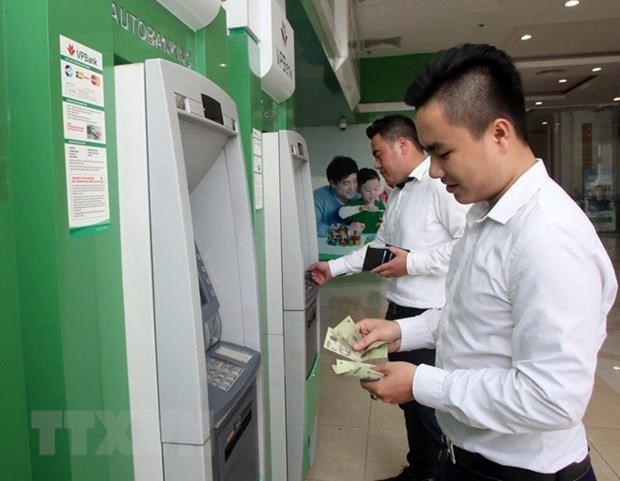 Office workers withdraw money from an ATM. (Photo: VNA) Office workers withdraw money from an ATM. (Photo: VNA)