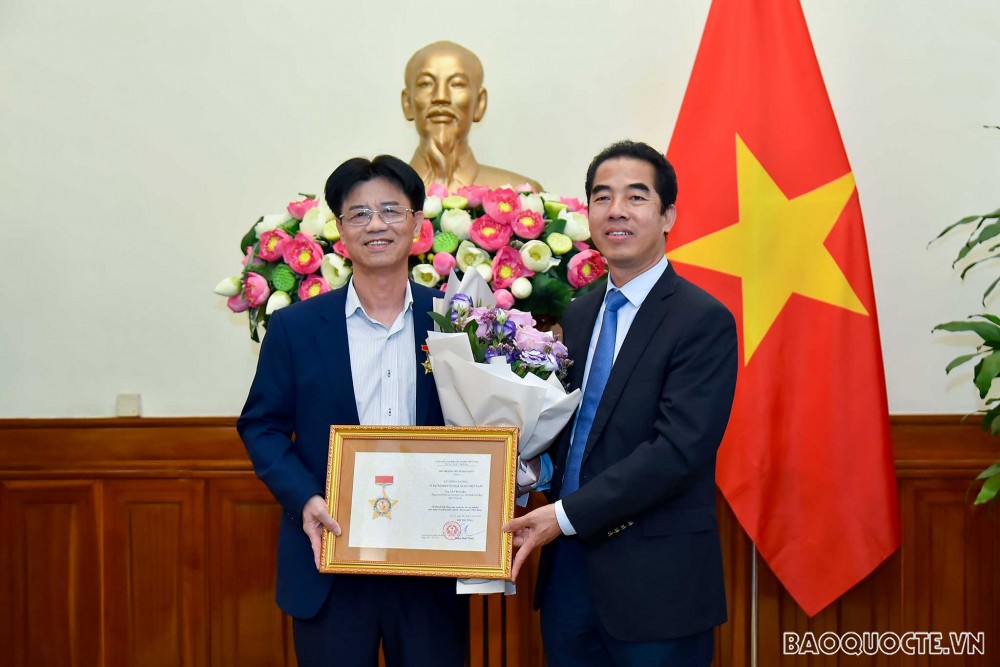 Thừa ủy quyền của Phó Thủ tướng, Bộ trưởng Bộ Ngoại giao Phạm Bình Minh, Thứ trưởng Ngoại giao Tô Anh Dũng đã trao Kỷ niệm chương “Vì sự nghiệp Ngoại giao Việt Nam” cho Đại tá Lê Văn Luận, Nguyên Phó Cục trưởng, Cục An ninh nội địa, Bộ Công an. (Ảnh: Tuấn Anh)