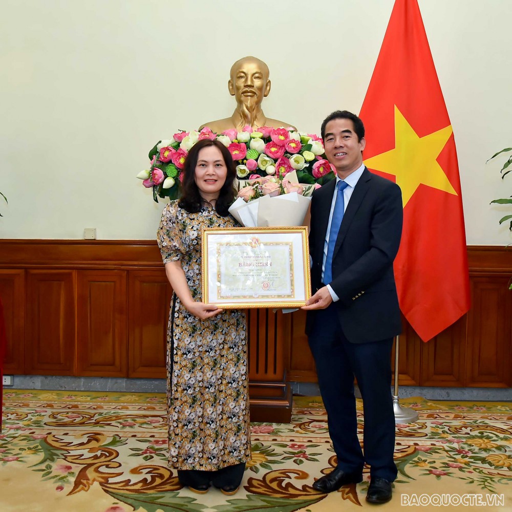 Thứ trưởng Ngoại giao Tô Anh Dũng trao Bằng khen của Bộ trưởng Bộ Ngoại giao cho bà Đào Thị Đượm, Phó Vụ trưởng Vụ Công giáo, Ban Tôn giáo Chính phủ, Bộ Nội vụ. (Ảnh: Tuấn Anh)