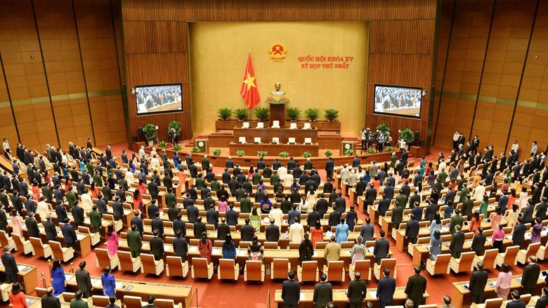 Toàn cảnh phiên khai mạc Kỳ họp thứ Nhất, Quốc hội khóa XV. Các đại biểu Quốc hội làm lễ chào cờ.