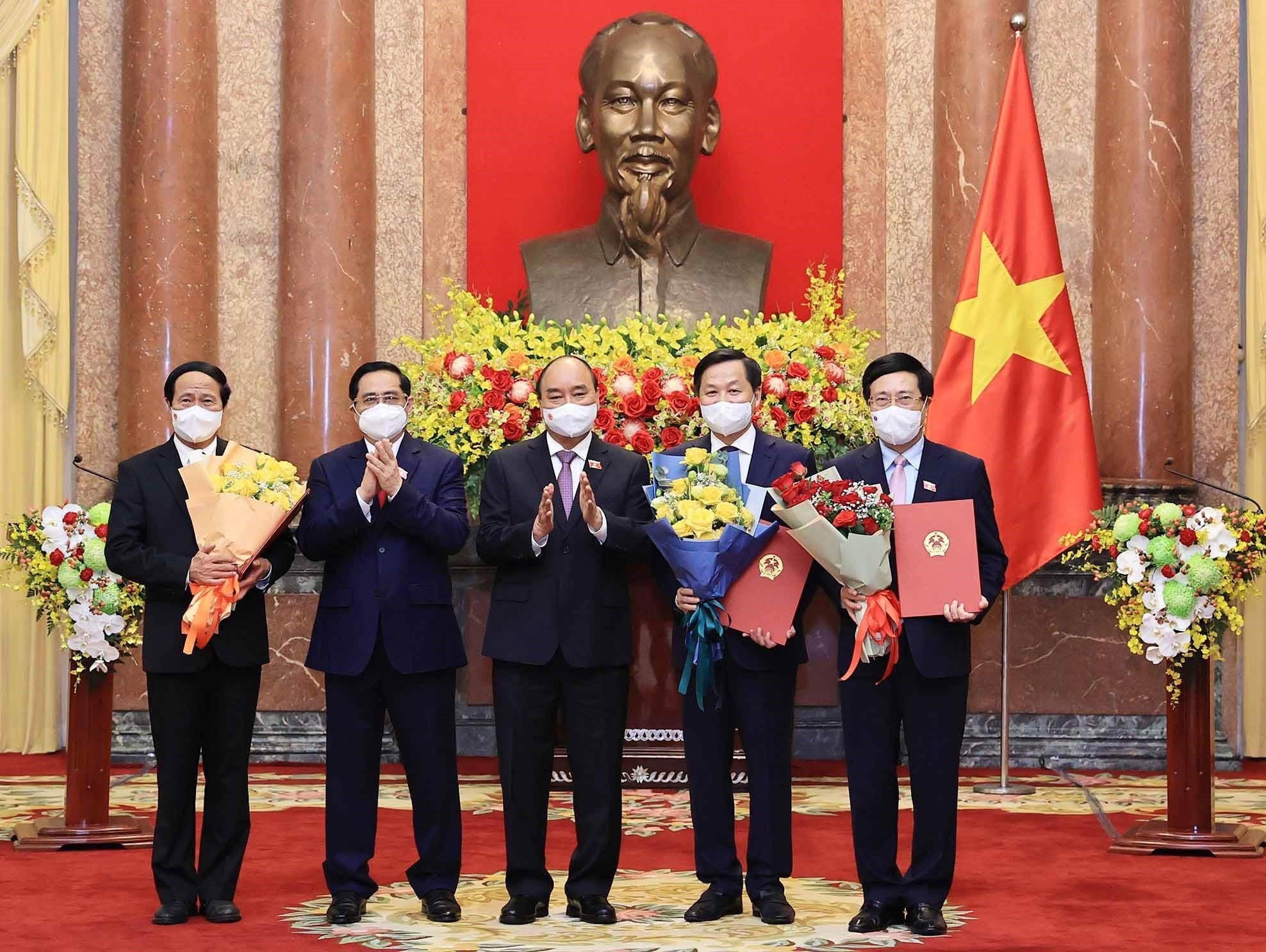 Chủ tịch nước Nguyễn Xuân Phúc trao Quyết định, Thủ tướng Phạm Minh Chính tặng hoa cho các Phó Thủ tướng Chính phủ.