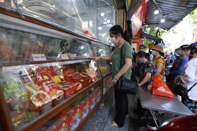 Người dân lựa mẫu mã, loại bánh tại một cửa hàng bán bánh Trung thu.