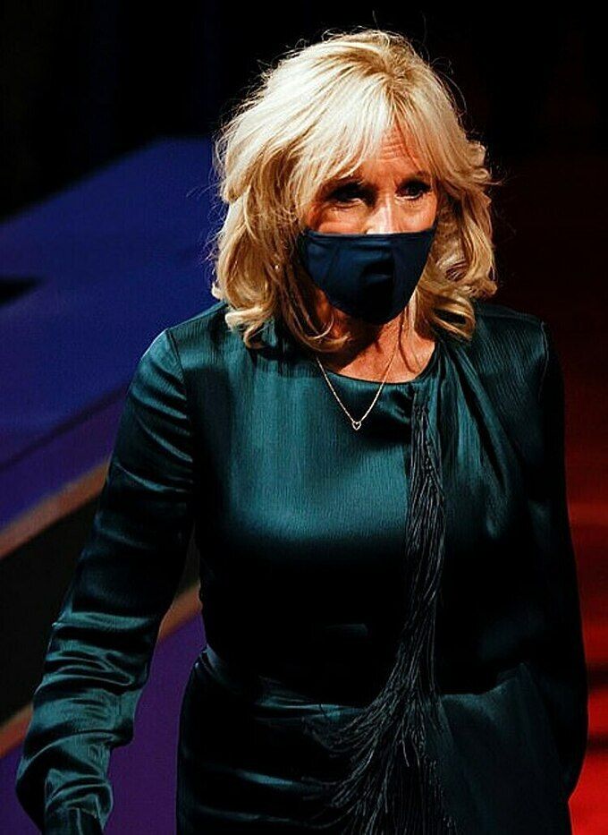 Cuối tháng 9, Jill diện đầm cũ tới buổi tranh luận tổng thống ở Cleverland, bang Ohio. Thiết kế làm từ lụa màu xanh lục bảo ngọc, đính những sợi dây kết cườm phía trước, từng được bà mặc vào tháng 10/2017 khi tham dự một sự kiện gây quỹ tranh cử cùng chồng ở thành phố New York. Ảnh: Reuters Bà Jill Biden thu hút với 'gu' thời trang thanh lịch